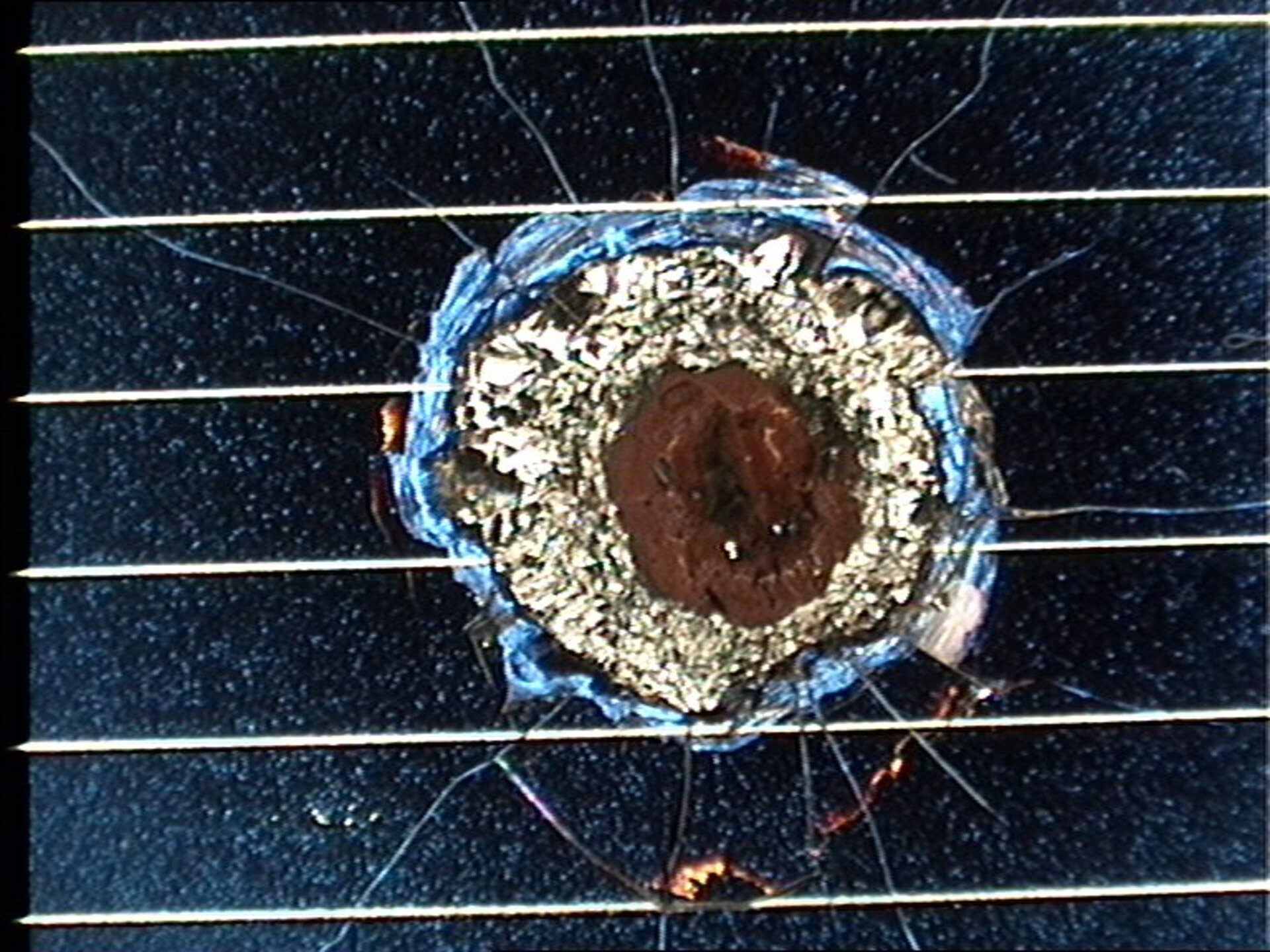 Un cratere da impatto su di un pannello solare di Hubble